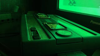 A cropped picture of Mattel's Intellivision console, reflecting light from a television.